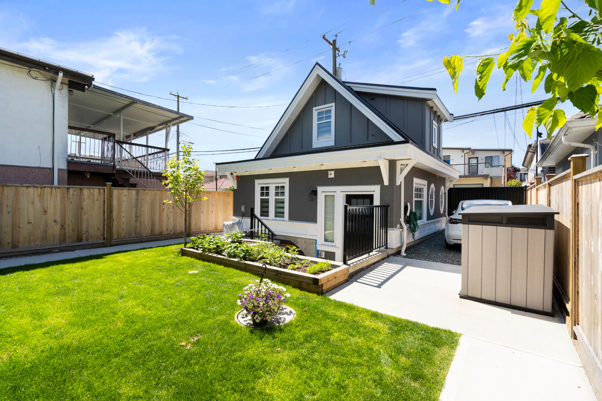 Photo grey Lane Way house with white trim and raised garden beds.