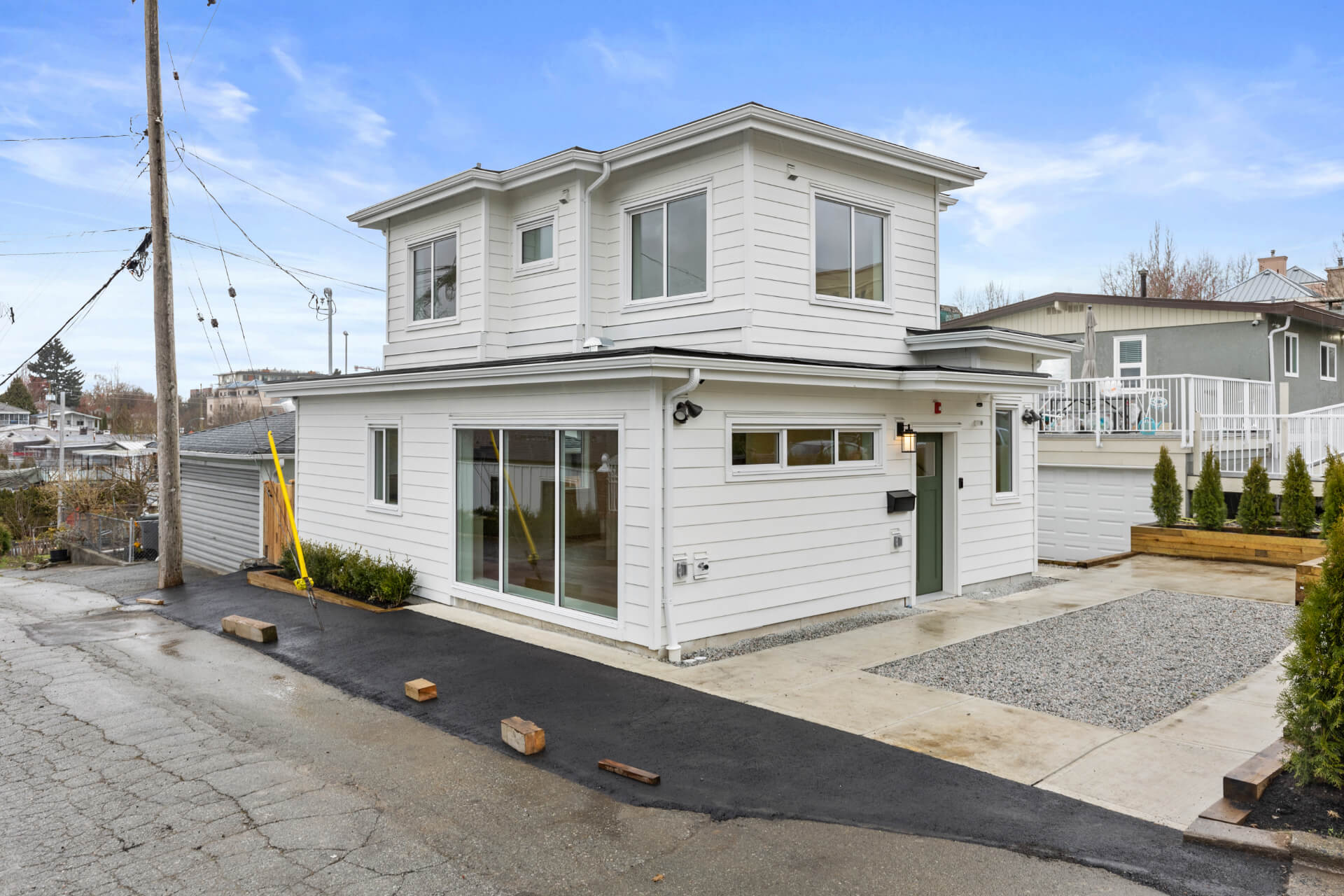 Photo of street view of white sided Lane way house.