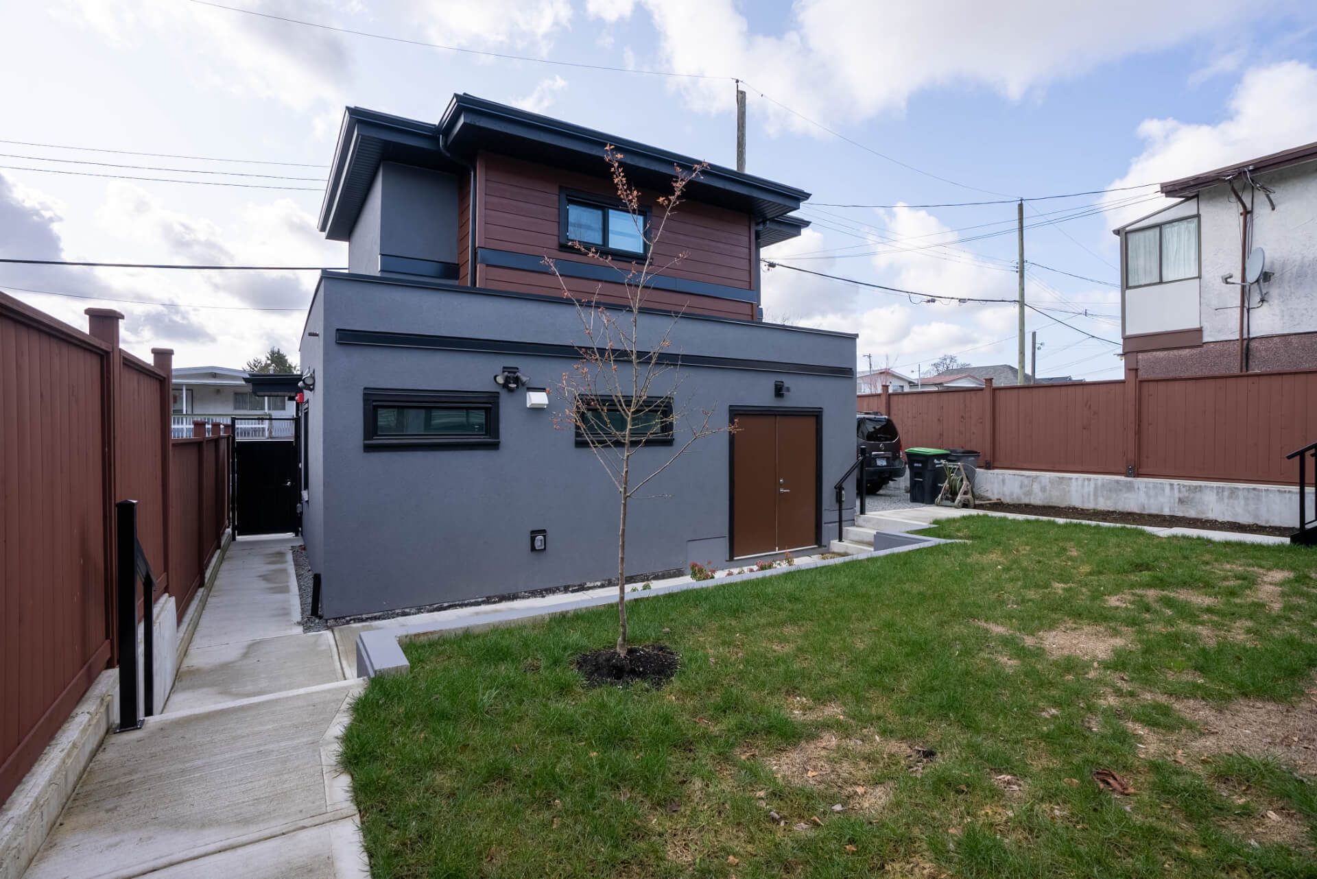 Grey and brown Lane Way house, with brown fenced in yard.