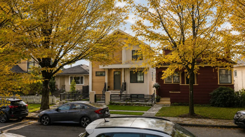 Modern contemporary custom home on a tree-lined street in the Sunset neighbourhood of South Vancouver with autumn foliage
